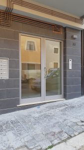 Portone di ingresso condominiale in alluminio a taglio termico con serratura elettrica. Sistema ICRA
